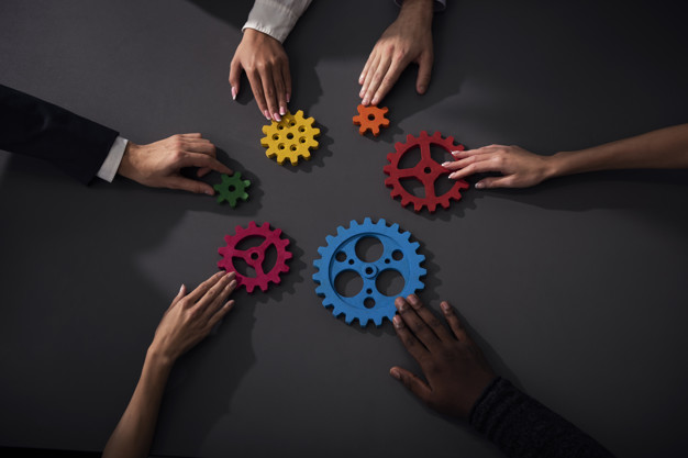 Business team connect pieces of gears. Teamwork, partnership and integration concept